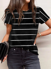 Woman in striped round neck short sleeve t-shirt and jeans with clutch