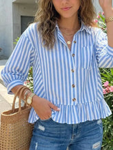 Blue and white vertically striped ruffle hem button-down shirt featuring a striped ruffle hem detail