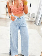 Light blue denim wide leg jeans with slit leg frayed sides decorative stitching and studded pockets