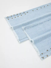 Light-wash denim wide leg jeans with slit leg frayed hems and gold-toned studs along the seams