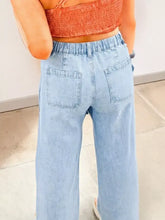 Light-wash denim wide-leg jeans with elastic waistband back pockets and studded side slit leg frayed details