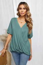 Woman in surplice half sleeve V-neck wrap top and blue jeans
