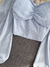 Light blue cropped Swiss dot blouse with ruched bodice and delicate white dot embellishments for a stylish look