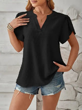 Woman in swiss dot notched petal sleeve T-shirt with denim shorts