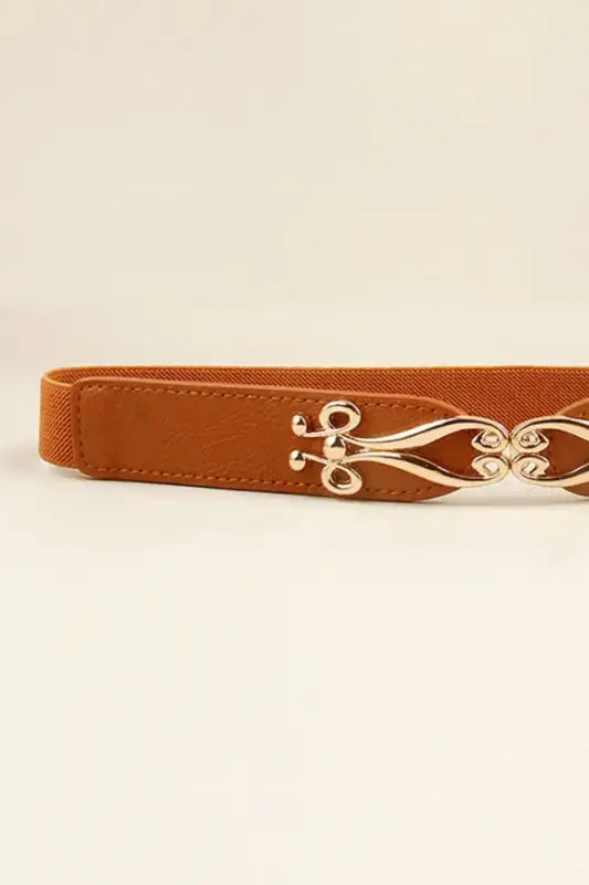 Tan alloy buckle elastic belt with ornate gold-toned scrollwork from Hipomarket