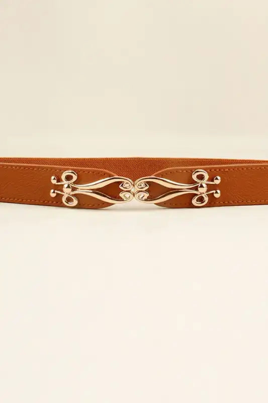 Tan alloy buckle elastic belt with ornate gold-toned design from Hipomarket