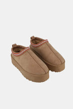 Tan platform slip-on boots with embroidered trim and 2-inch heel height