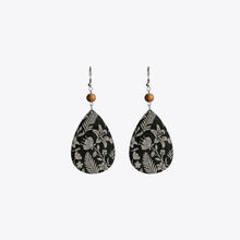 Teardrop drop earrings with white floral patterns and wooden beads on black