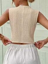 Beige textured button sleeveless crop top with lightweight fabric and relaxed fit in a textured button-front vest style