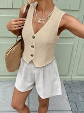 Beige textured button-front vest with dark buttons showcasing a sleeveless textured button design