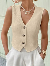 Beige textured button-front sleeveless vest with three dark buttons and a subtle fabric pattern