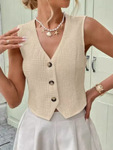 Beige textured button sleeveless vest with v-neck and three dark buttons in a textured button-front design