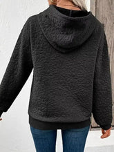 Black quilted floral hoodie featuring textured design made for machine wash cold care instructions