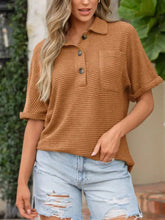 A rust-colored textured knit button detail top with waffle-knit fabric, collar, and three dark buttons