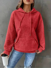 Red textured knit drawstring hoodie with front pocket made of slightly stretchy fabric machine wash cold