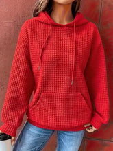 Red textured knit drawstring hoodie with front pocket in slightly stretchy fabric suitable for machine wash cold