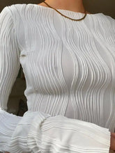 A white textured long sleeve fitted blouse with a wavy pleated design in a soft fabric