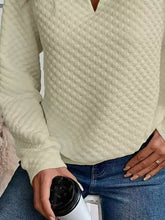 Cream-colored textured notched raglan sleeve sweatshirt with v-neck and long sleeves in slightly stretchy material