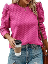Vibrant pink textured round neck long sleeve blouse with puffed sleeves made of slightly stretchy knit material