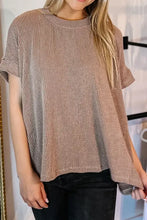 Woman in textured round neck short sleeve T-shirt and black jeans