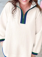 Cream-colored textured waffle knit half-zip sweatshirt with green and navy trim in slightly stretchy waffle knit material