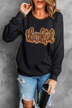 Thankful round neck long sleeve sweatshirt with gold glitter design on black fabric and distressed denim shorts