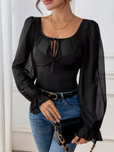 Black sheer flounce sleeve bodysuit with long sleeves, ruffled cuffs, square neckline, and tie front detail