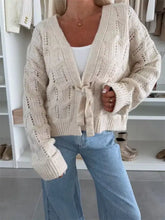 Cremefarbener, vorne zum Knoten offener Strickcardigan mit grobem V-Ausschnitt