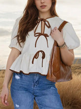 White puff sleeve peplum blouse with brown tie details and ruffled hem in lightweight fabric for elegant wear