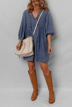 Beige crossbody bag with stitched detailing and shoulder strap paired with a slightly stretchy mini denim dress
