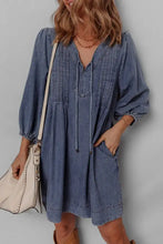 Blue slightly stretchy mini denim dress with puffed sleeves and a tie neck long sleeve neckline