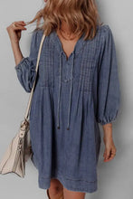 Blue slightly stretchy mini denim dress with v-neck, pleated front, and drawstring tie long sleeves