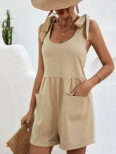Beige tie shoulder romper with bow details and front pockets