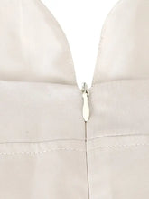 A sleek off-white tie shoulder satin cami featuring a matching zipper pull in smooth white satin fabric