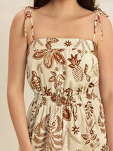 Cream-colored tie strap wide leg jumpsuit with brown botanical prints
