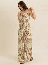 Woman in tie strap wide leg jumpsuit with floral print