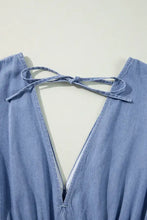 Light blue denim dress with deep tied plunge v-back and matching fabric ties showing back view care instructions available