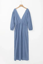 A soft blue denim dress with a tied plunge deep v-neckline and gathered waist with three-quarter sleeves and care instructions