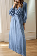 A flowing light blue denim dress with tied plunge v-neckline and long puffed three-quarter sleeves and care instructions