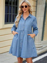 Light blue tiered button up long sleeve denim dress with button front design and two front pockets