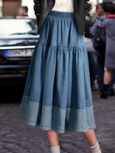 A tiered denim midi skirt in soft blue wash with subtle stitching details perfect as a stylish denim midi skirt