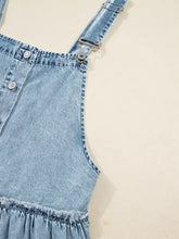 Tiered flowy overall denim dress in light-wash denim with silver-toned buttons and adjustable metal clasps suitable for machine wash care instructions