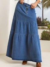 A medium-wash blue tiered maxi denim skirt with ruffles and a front zipper closure for stylish wear