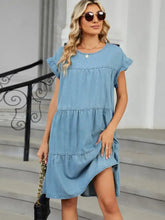 A light blue denim dress with tiered ruffles and short flutter sleeves featuring a tiered round neck short design