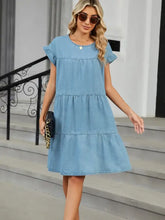 Light blue denim dress with tiered round neck and short flutter sleeves in a round neck short sleeve denim dress style