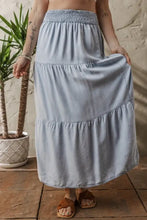 Light blue tiered wash denim maxi skirt with gathered elastic waistband and flowy tiered design