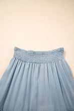 Light blue tiered wash denim maxi skirt with smocked elastic waistband and flowing fabric design
