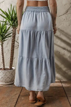 Light blue tiered denim maxi skirt with smocked elastic waistband for comfortable casual wear