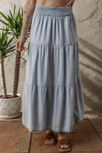 Light blue tiered denim maxi skirt with elastic smocked waistband and soft fabric for comfortable wear