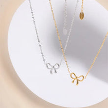 Titanium steel bow pendant necklace with gold accents and delicate chain